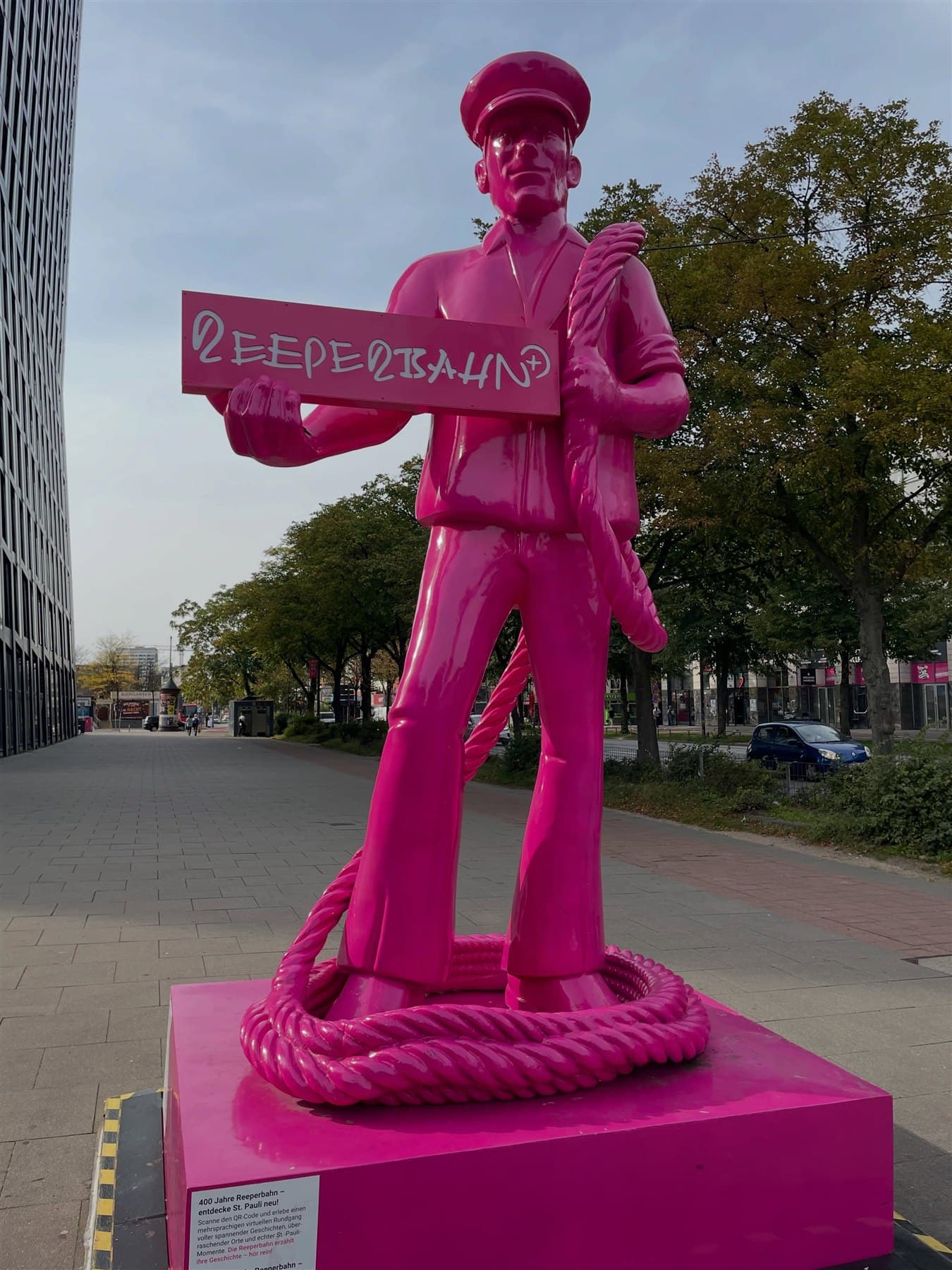 Bright pink sailor statue on Reeperbahn during a quiet afternoon