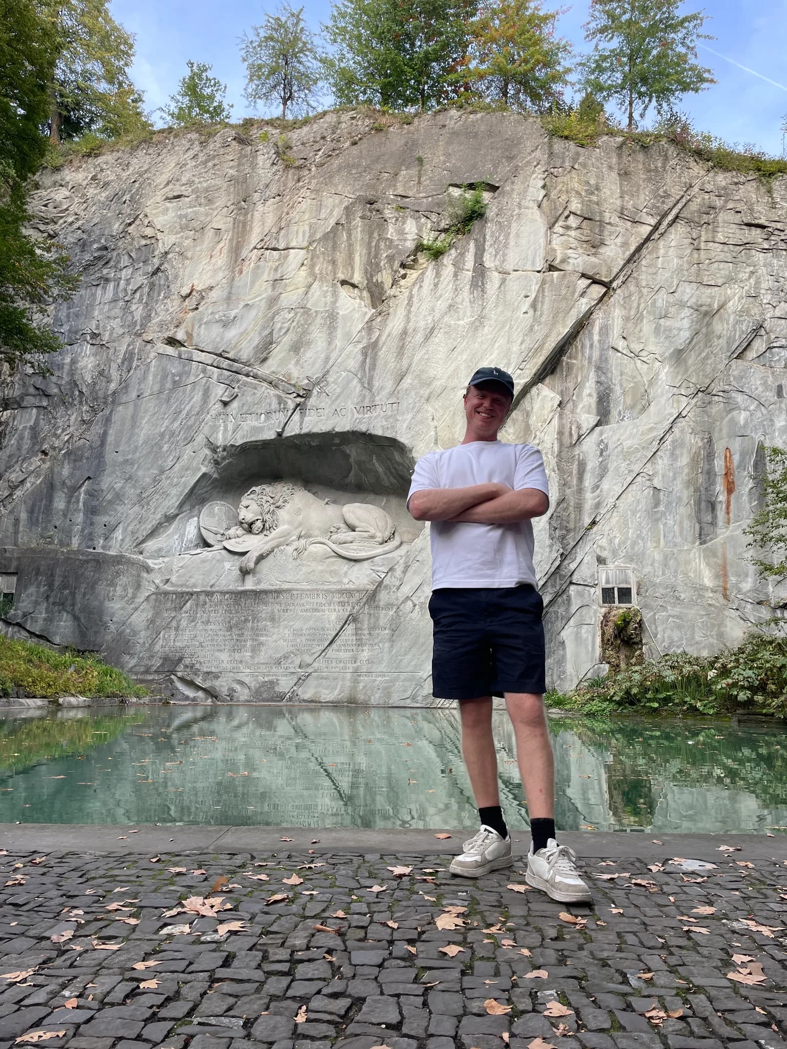 Traveller beside the Lion Monument carved into a rock face in Lucerne