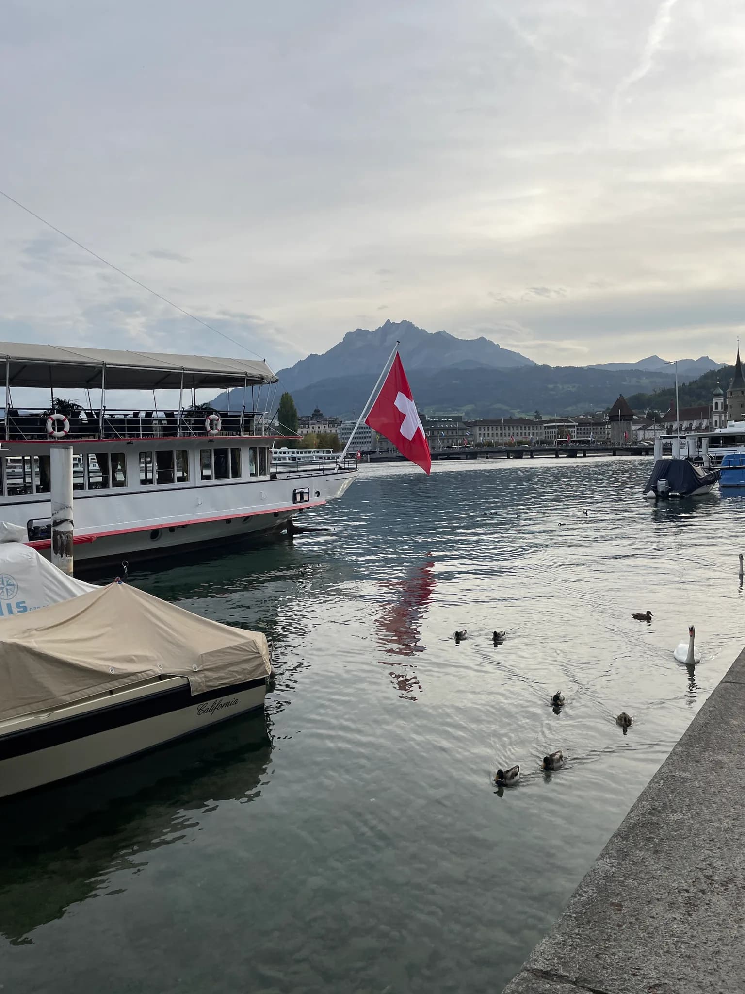 Mount Pilatus visible beyond boats and Lake Lucerne near Chapel Bridge
