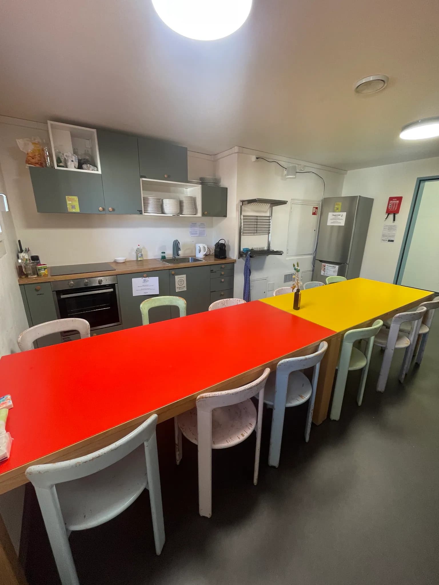 Shared guest kitchen and dining tables inside Bogentrakt Hostel Chur