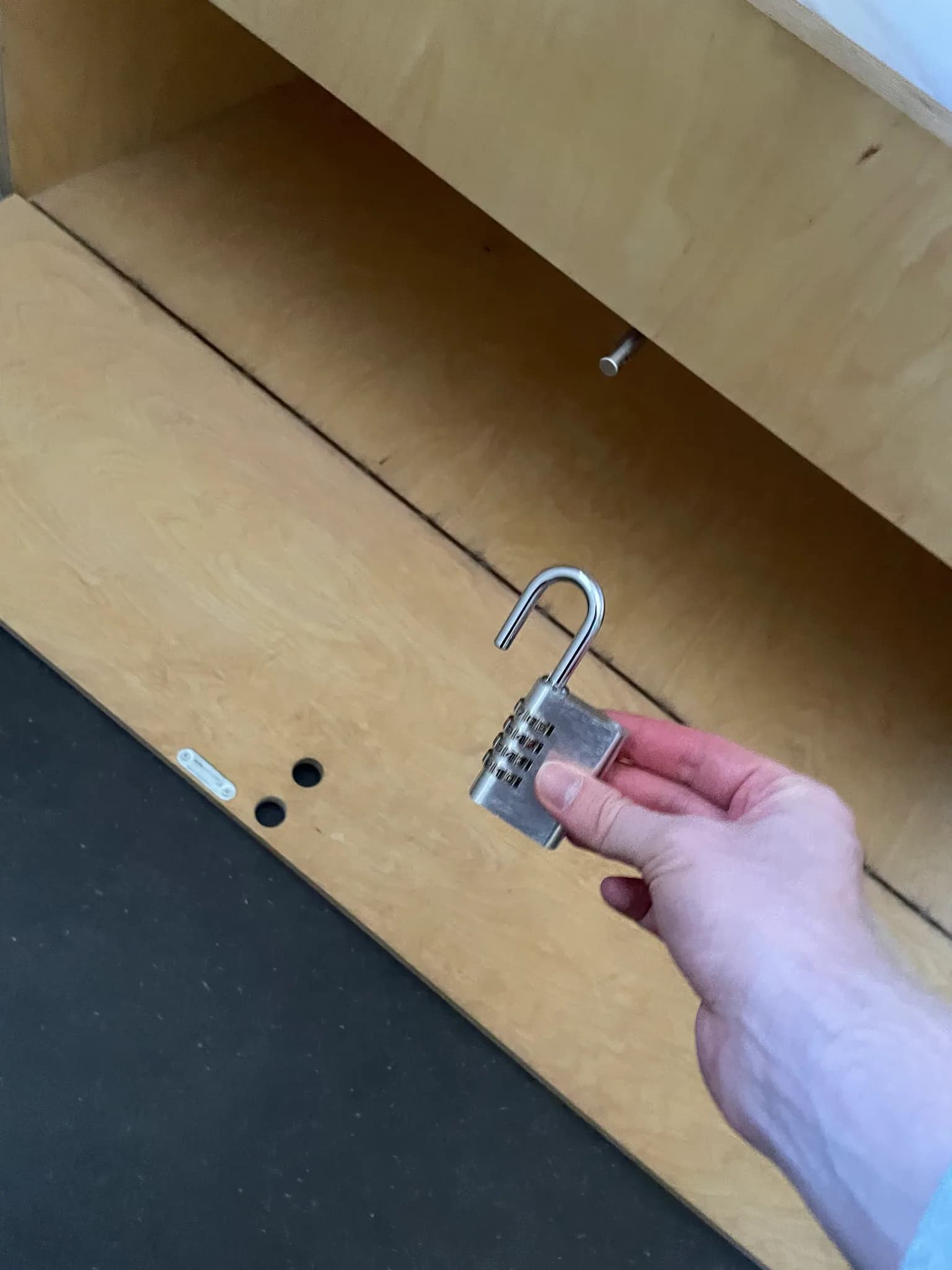 Wooden luggage locker beneath a dorm bed at Bogentrakt Hostel with a personal padlock