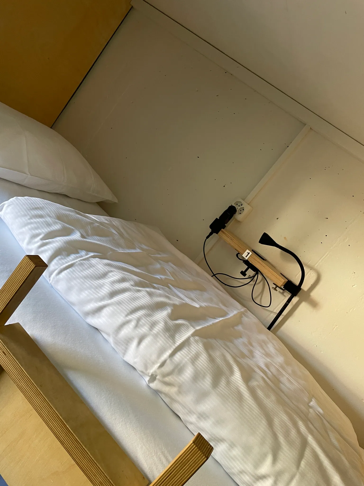 Pod-style dorm bed with privacy curtain, reading light and power outlet at Bogentrakt Hostel