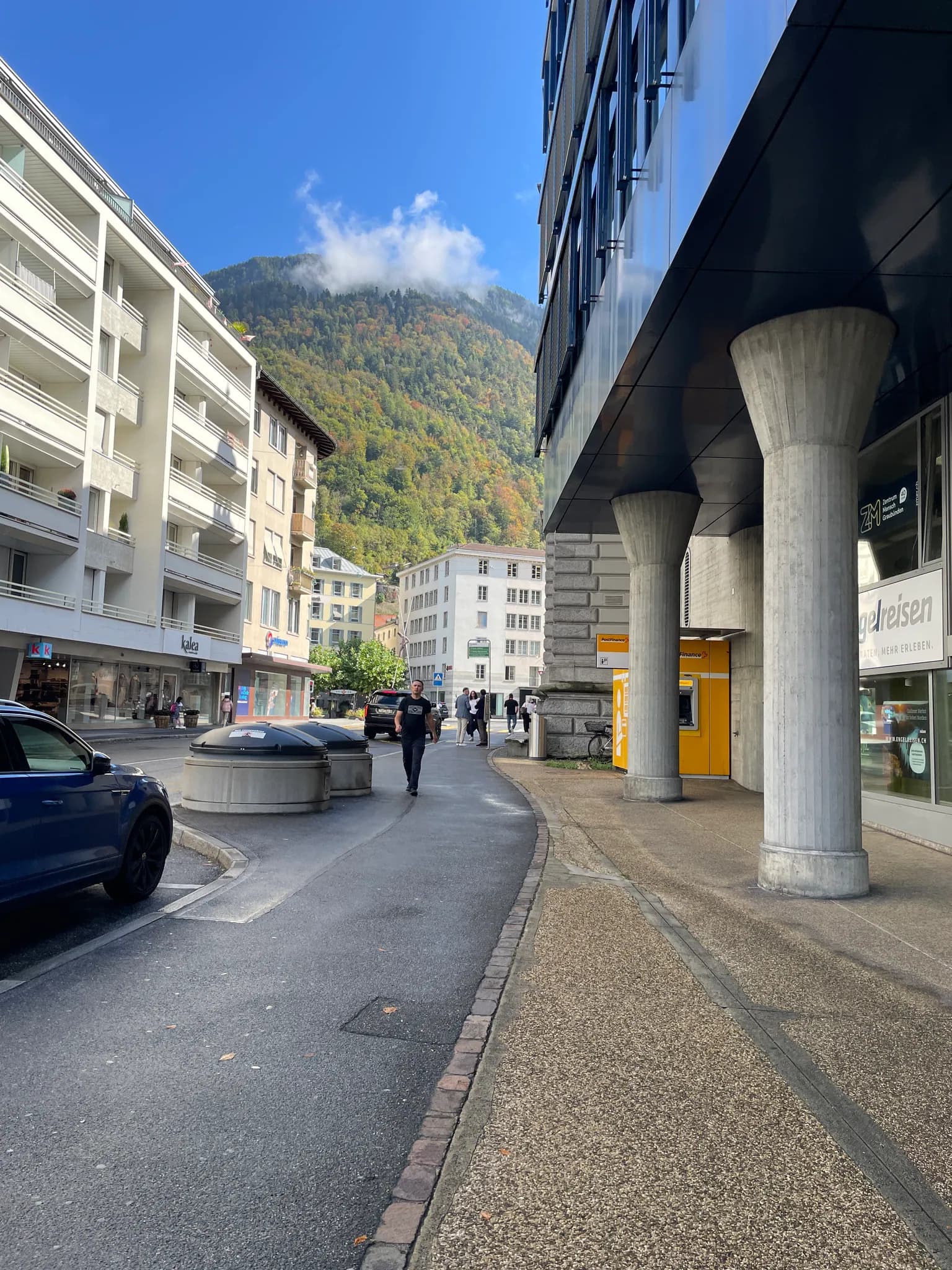 A street in central Chur with forested mountains rising behind the buildings