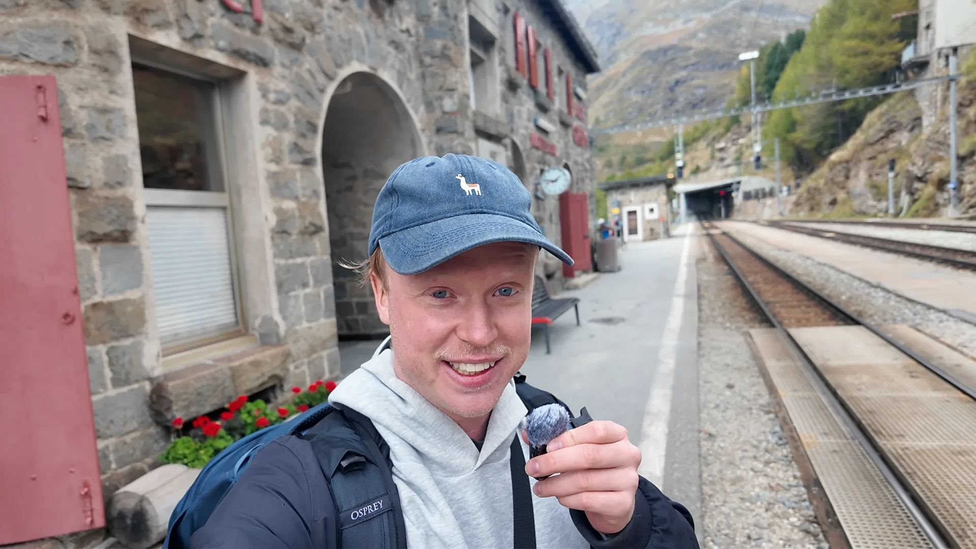 Traveller at the Alp Grüm viewpoint during a regional-train journey to Tirano