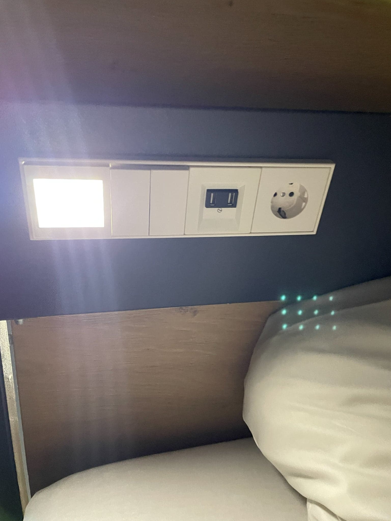 Lower dorm bunk with pillow, reading light, USB port, and power outlet at Generator Hamburg