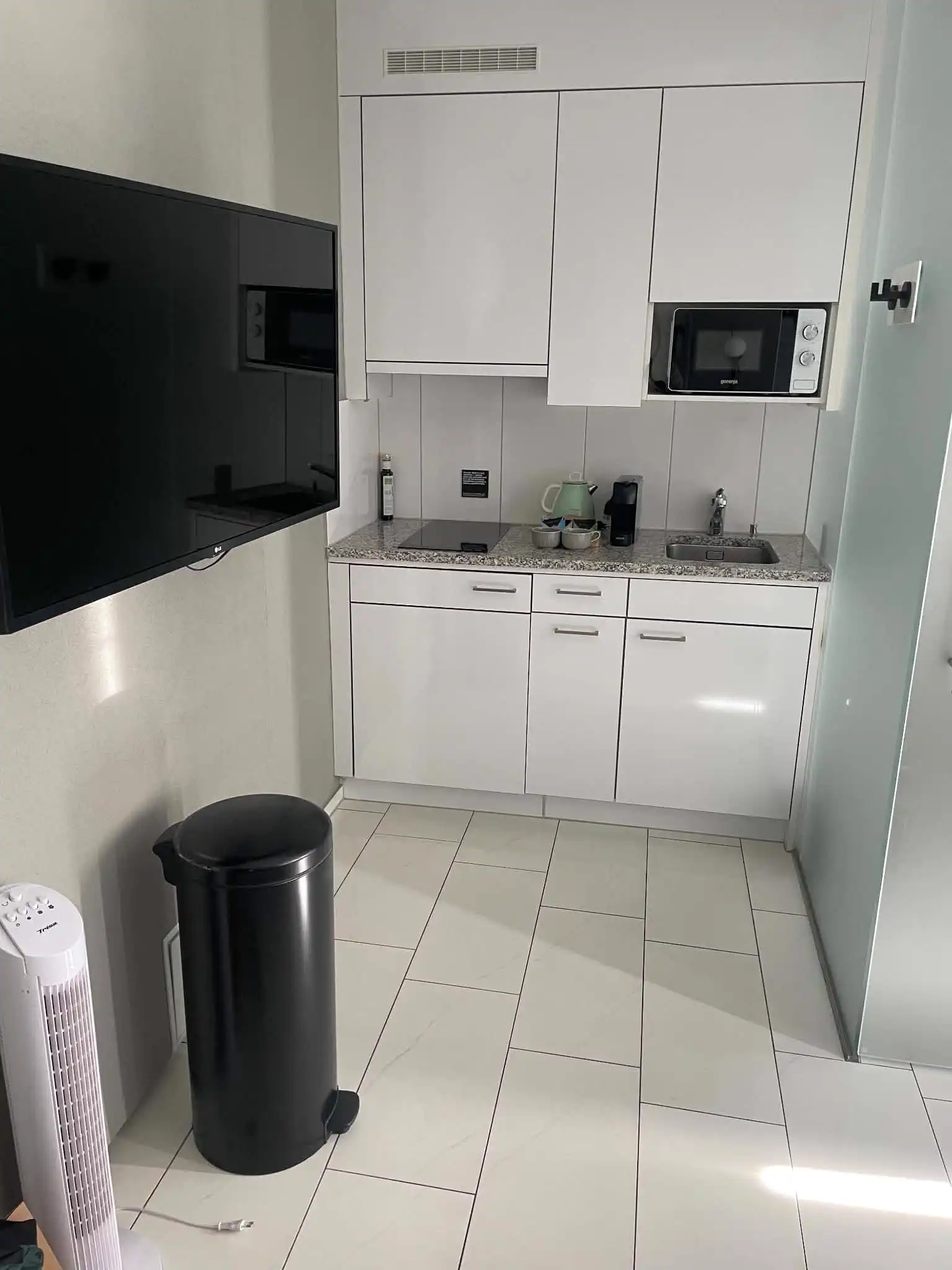 Compact kitchenette, television, coffee, and tea inside a studio at Hotel Numa Zurich Turi
